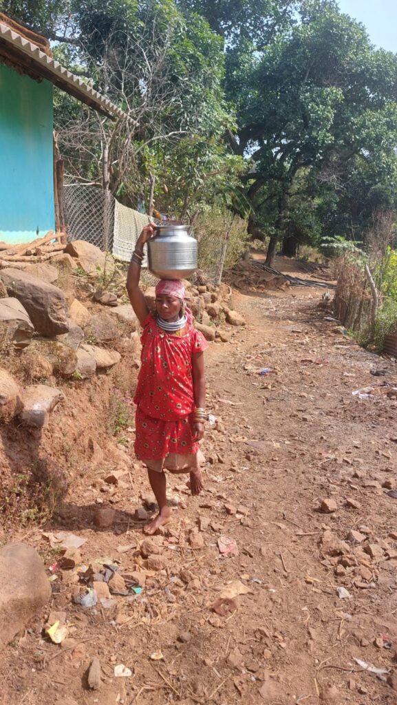 A woman in a rural village collecting water from a handpump during a severe water crisis